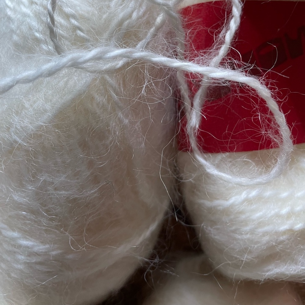 Ten skeins of white Mohair wool yarn.